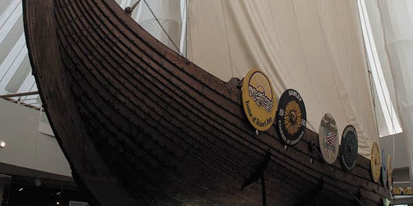A viking ship with round shields mounted on its side.
