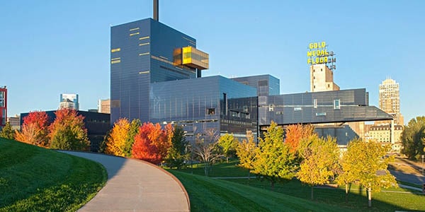 A modernistic cobalt blue and yellow building sits at the end of a winding path.