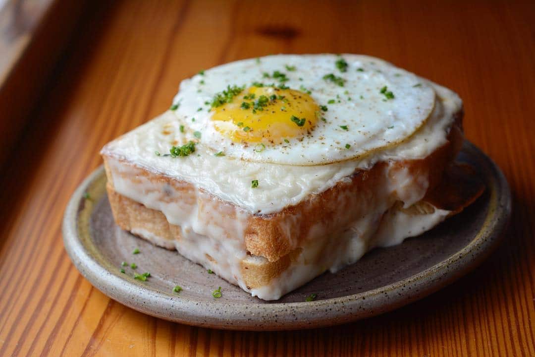 Two thick pieces of toast with melted cheese and eggs 