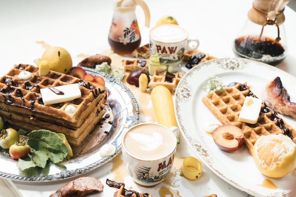 Beautiful breakfast display of waffles, fruit, syrup and coffee on table