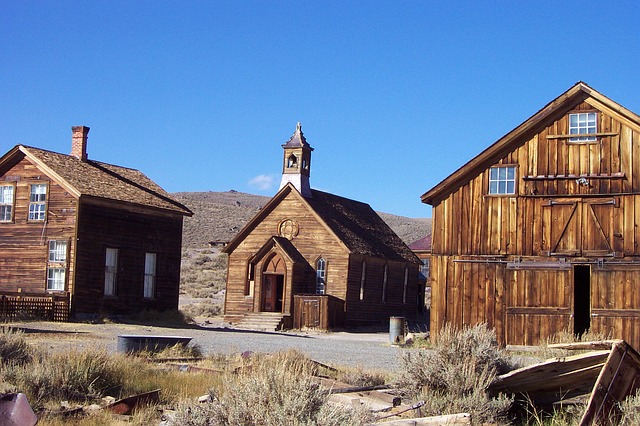 Abandoned ghost town, three wooden buildings, one of them a church.