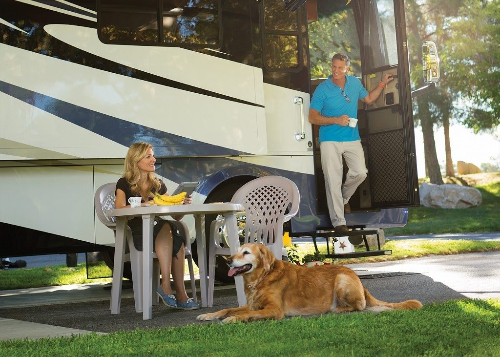 Couple chatting at table outside of large RV
