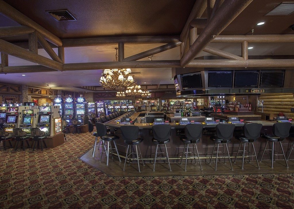 Interior view of bar at casino with slot machines in background