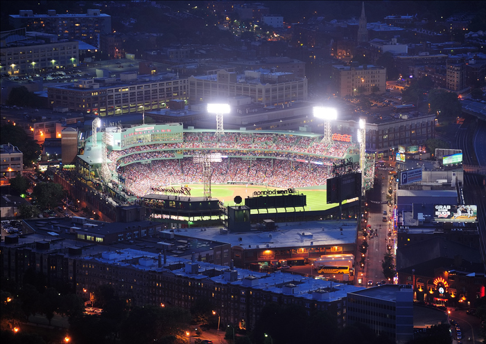 "Boston, Massachusetts, USA - June 20, 2011: Fenway Park stadium aerial view at night illuminated by lights with base ball game going on."