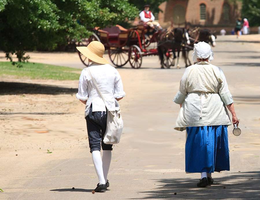 Costumed reenactors walk the streets of Colonial Williamsburg.
