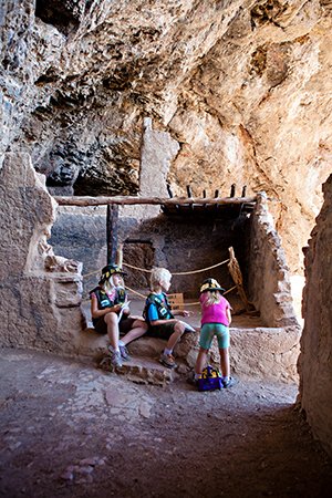 Three kids in the Tonto National Monument amid Native American ruins.