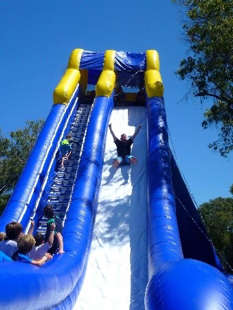 Man sliding down large blue and white inflated slide