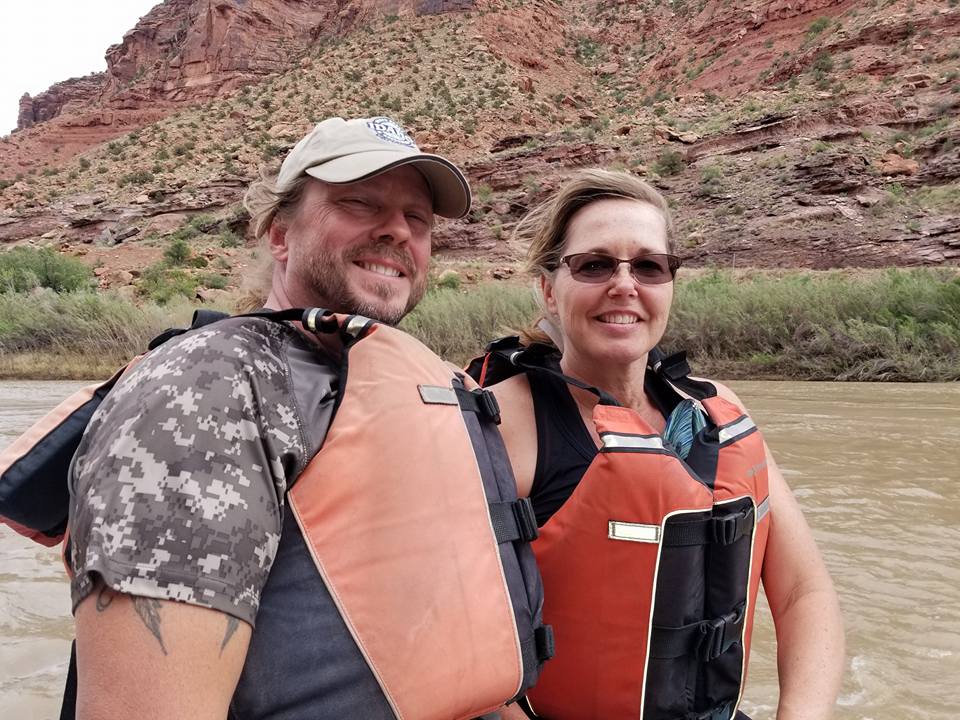 A couple on a Utah riverbank with life jackets. 