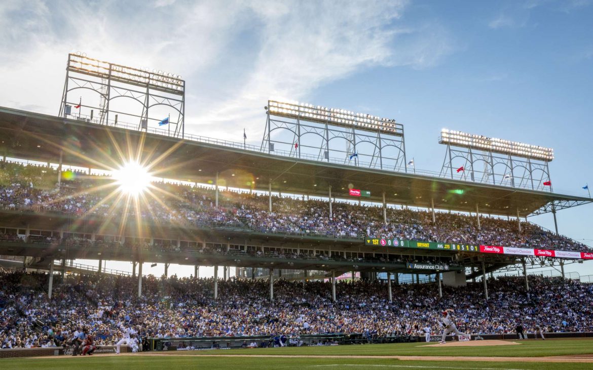 Wide view of Chicago Cubs batter on Wrigley Field with sun in background