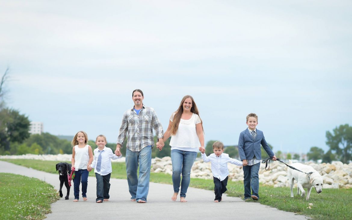 Nice looking family of six walking down road near beach