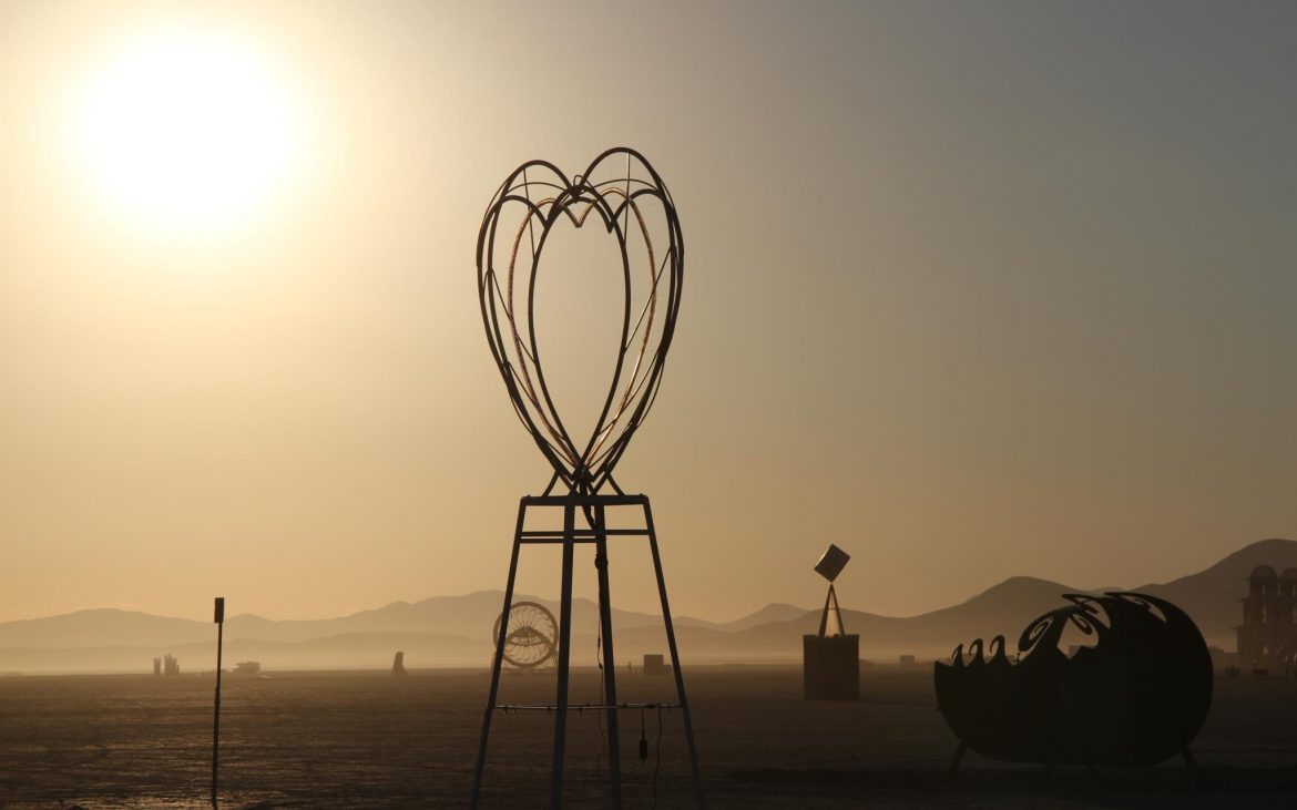 Metal heart sculpture in desert sun