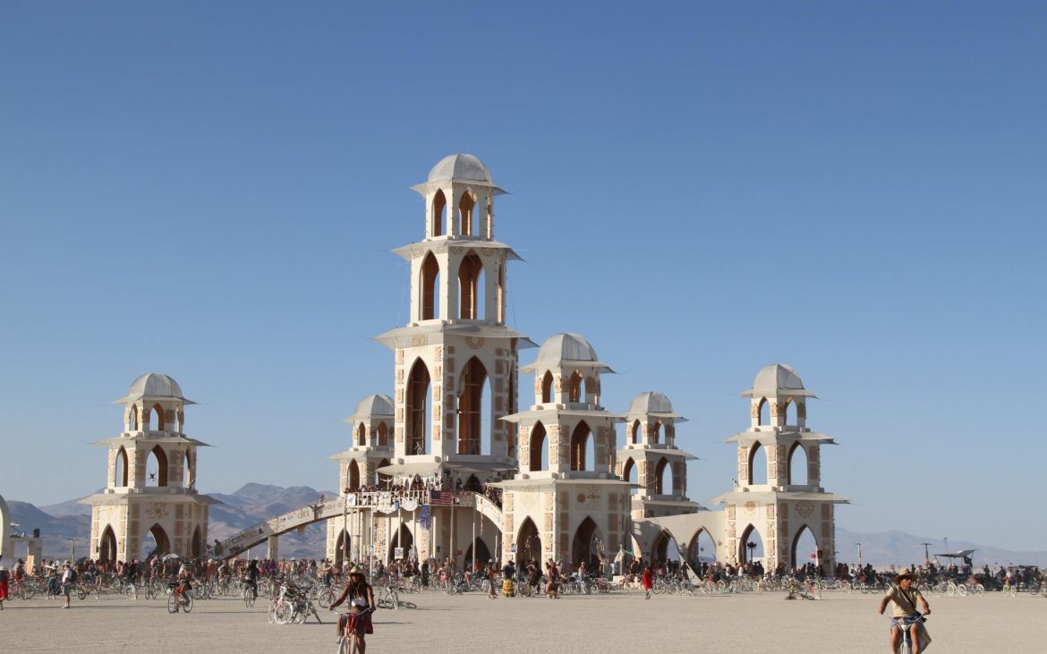 Temple at Burning Man with people on bicycles