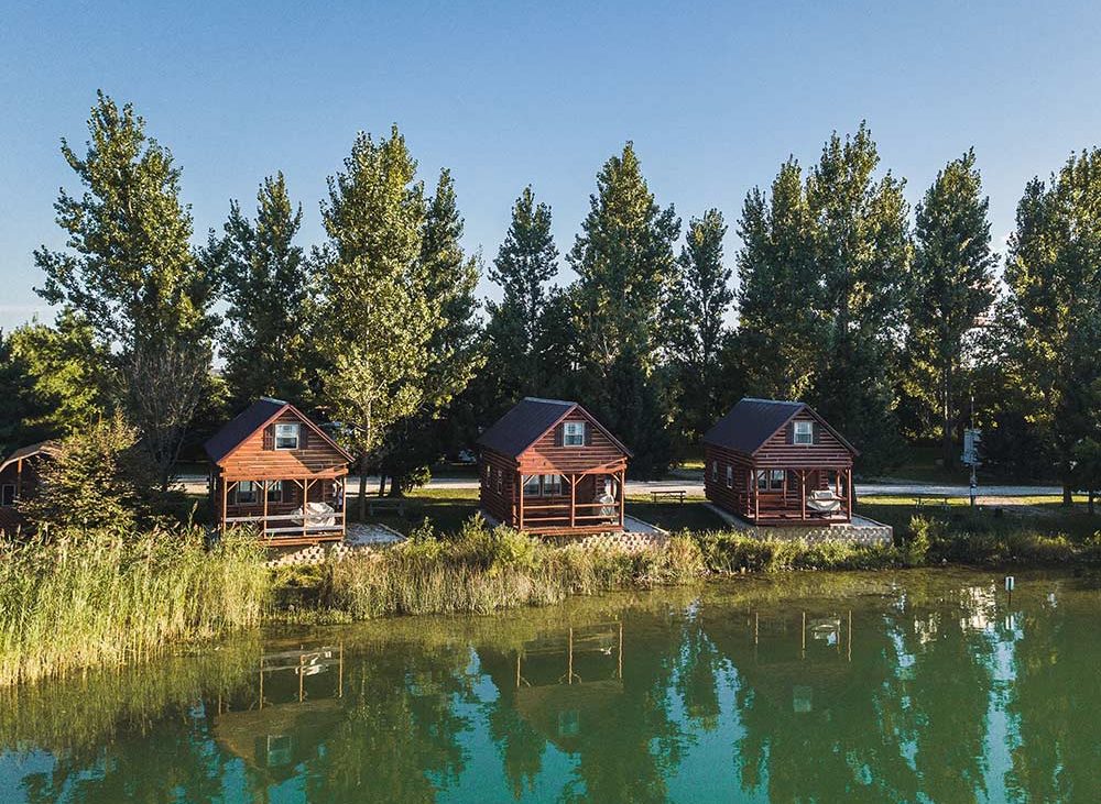 Wooden cabins along tree line and water
