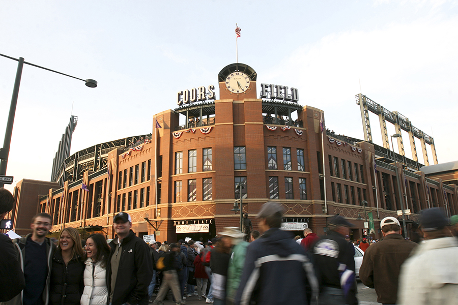Baseball lovers gather outside the entrance of Coors Field, which sports a throwback exterior design.