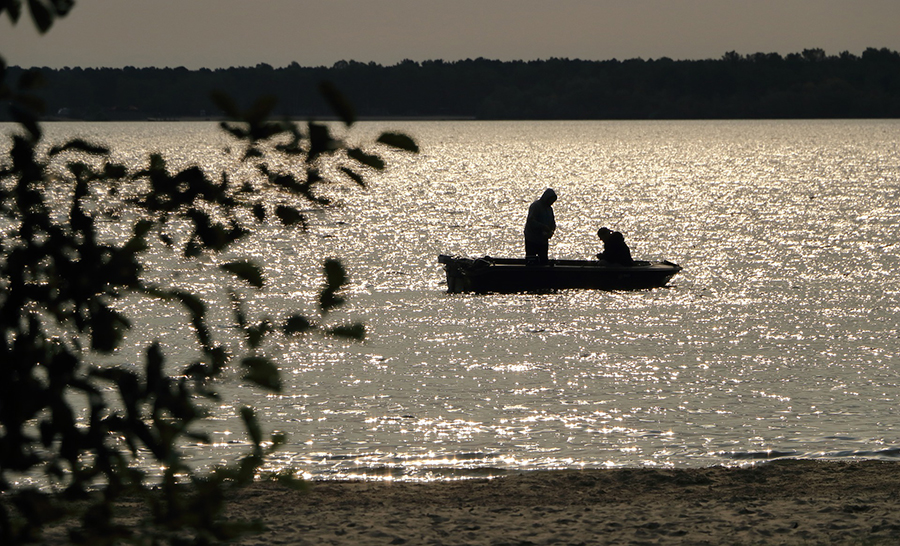 Silhouettes of a father and daughter on a lake at sunrise