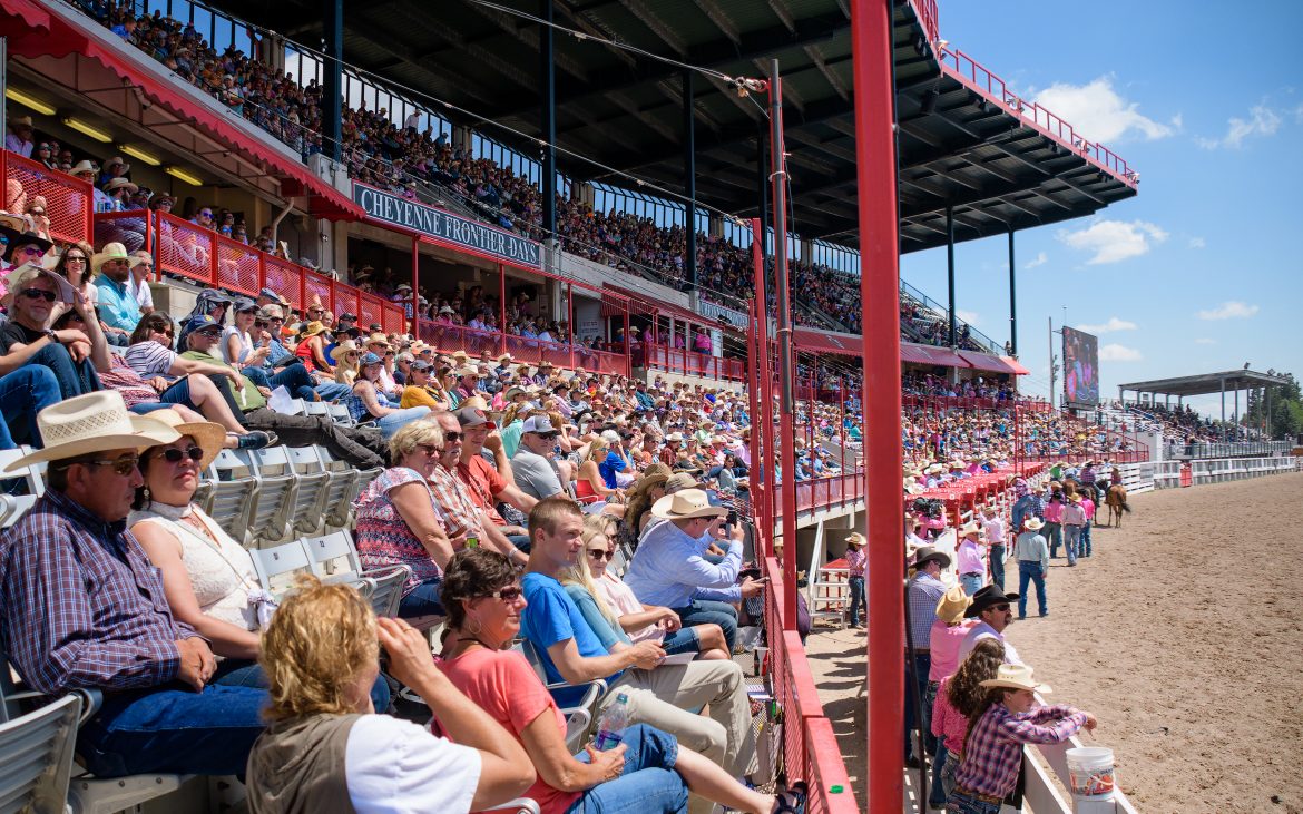 People in stands at rodeo on sunny day