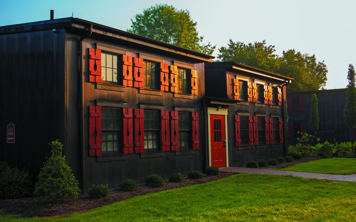 Brown building with red accents with manicured green lawn