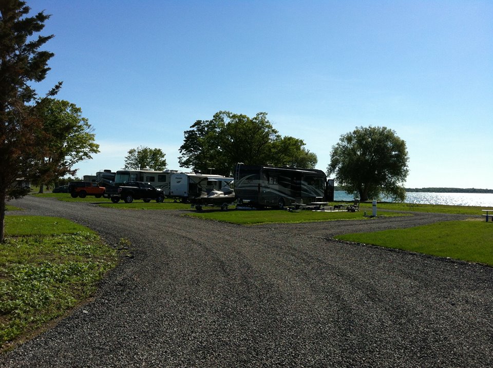 Many RVs parked along gravel and dirt road