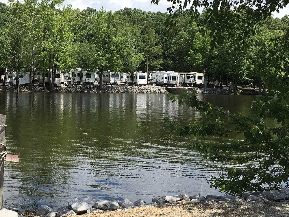 Many white RVs parked along the water