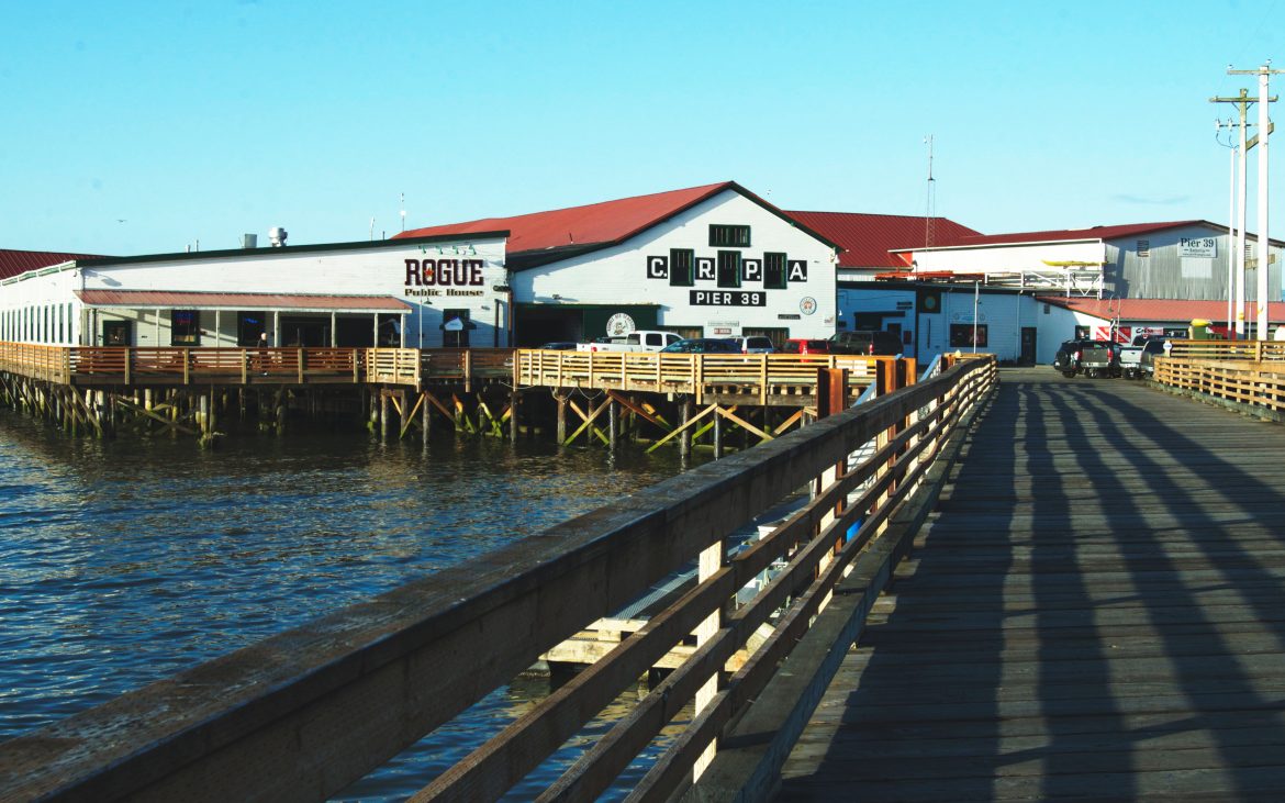 Brewpub white and red building on pier on ocean