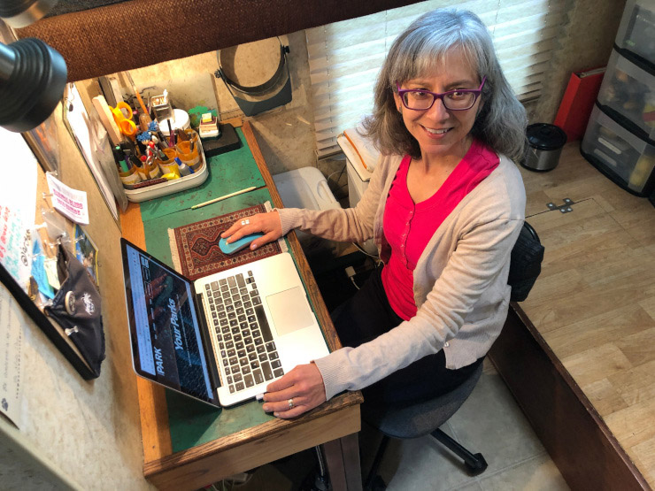 Author Rene Agredano seated at her computer desk in a renovated space in the RV.