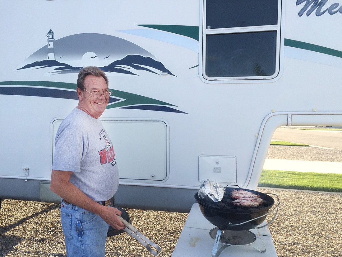 Grilling up a pair of juicy steaks outside of the fifth-wheel trailer.