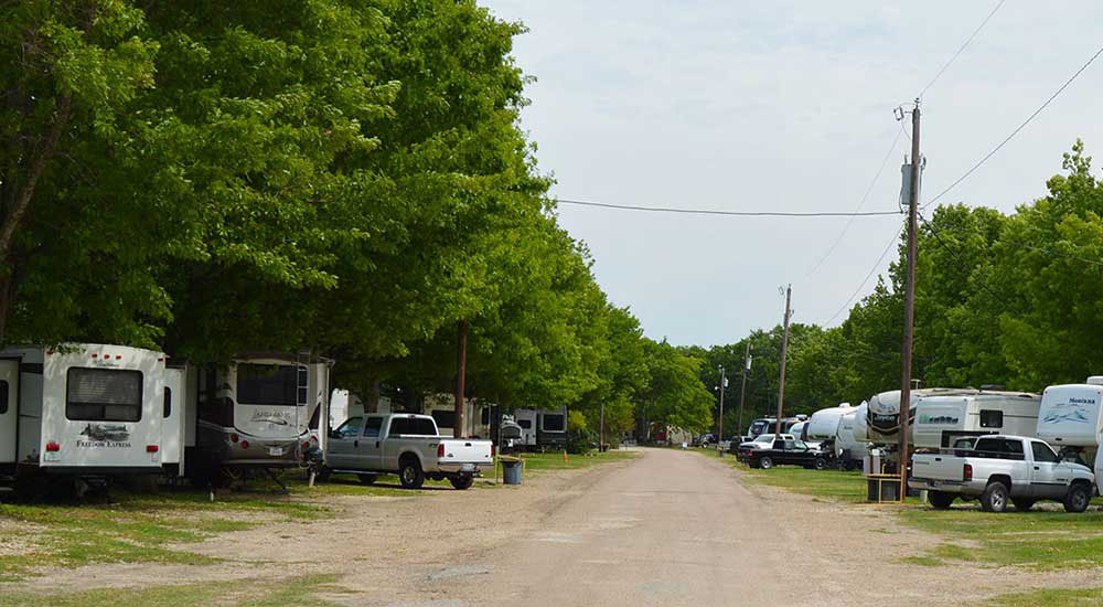RVs parked under shade trees at Riverview Campground in Waco