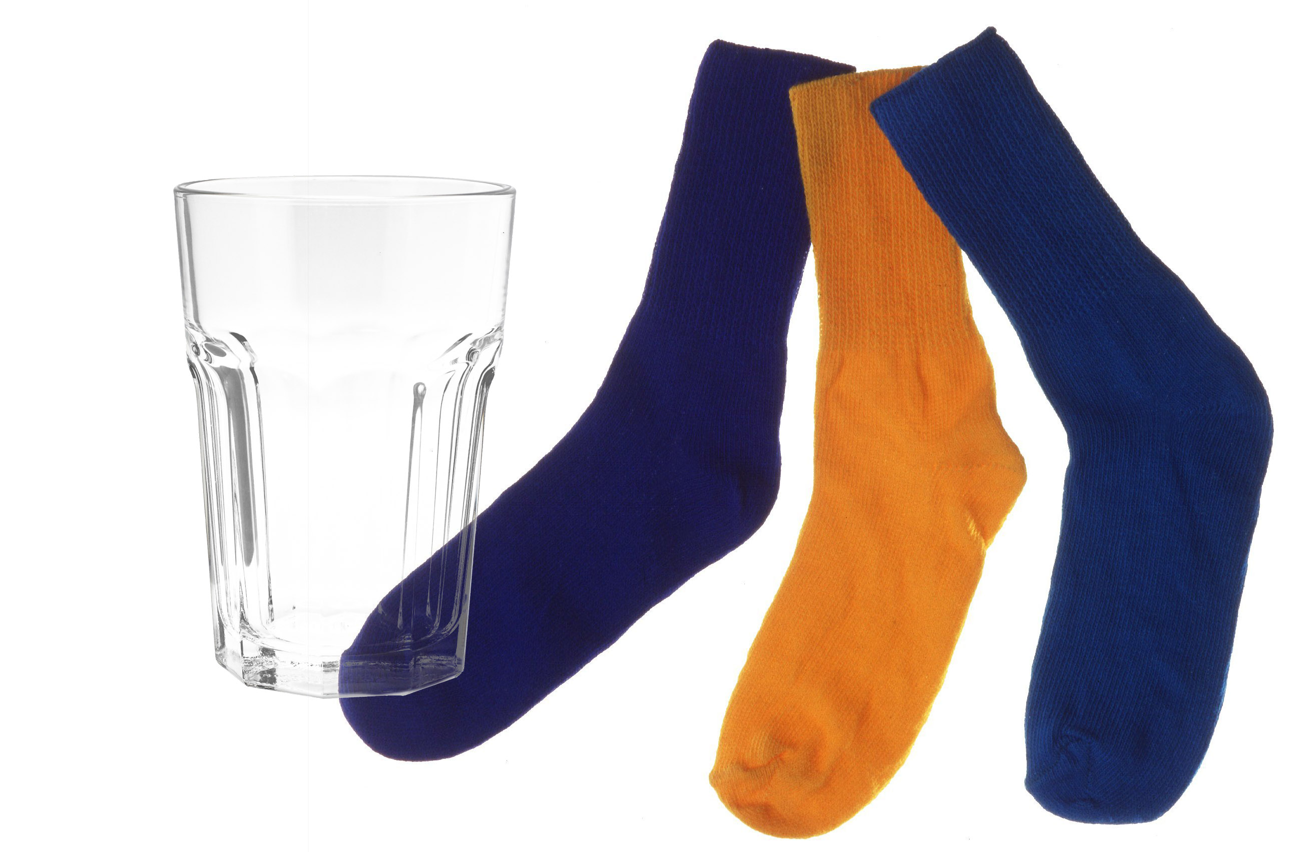 A clear water glass juxtaposed with some socks.