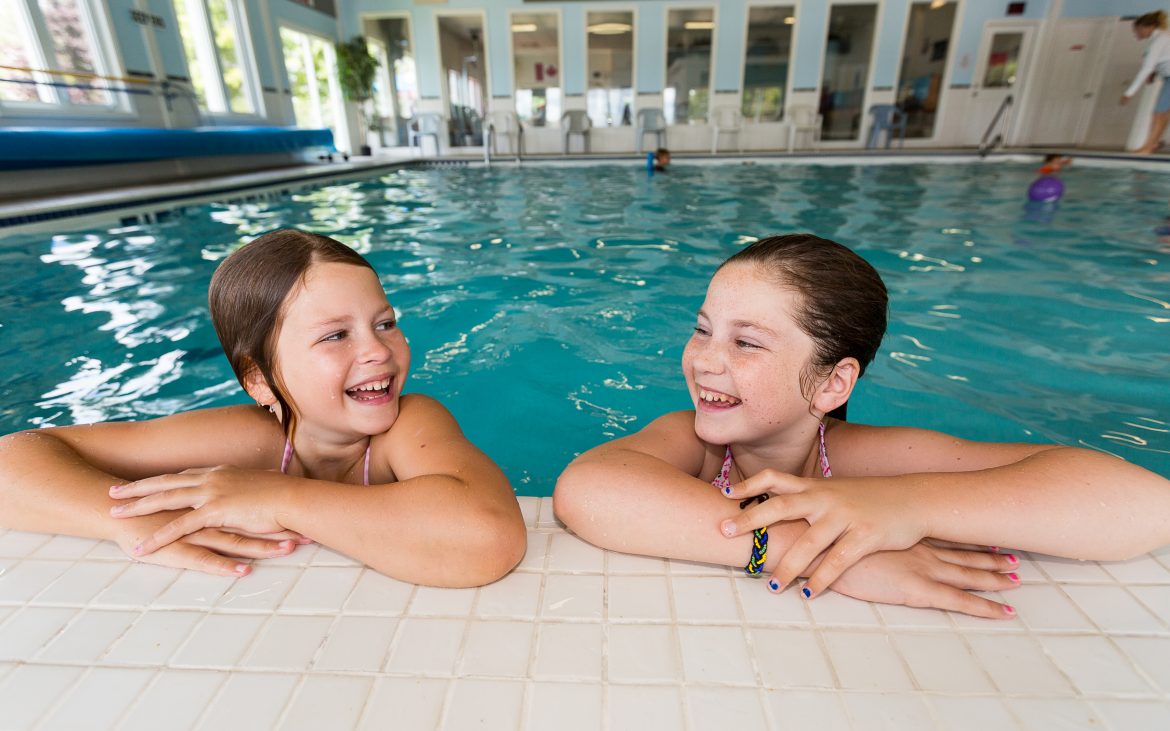 two young girls playing in indoor pool