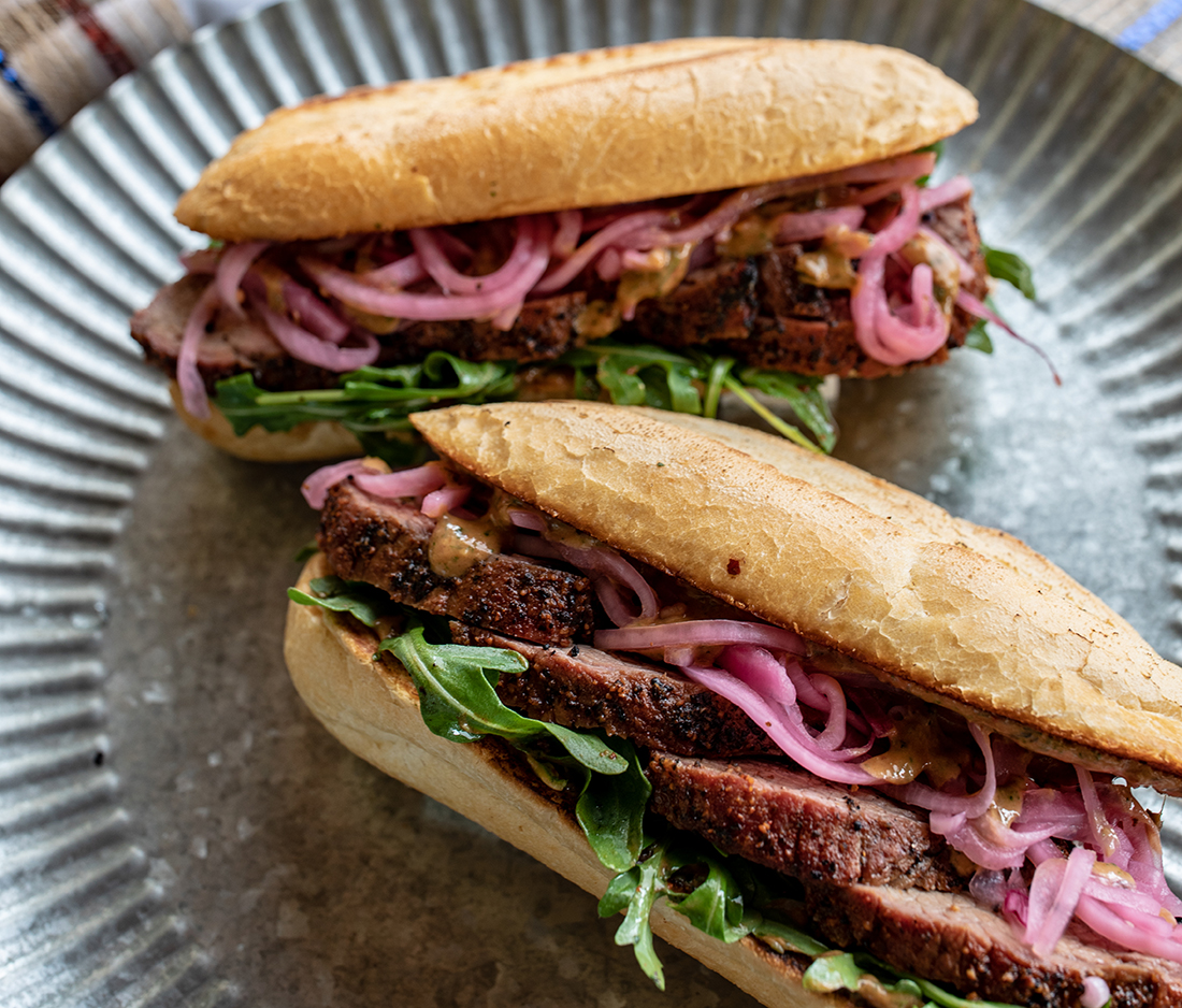 Tri-tip sandwiches with pickled onions, spinach and mustard sauce.