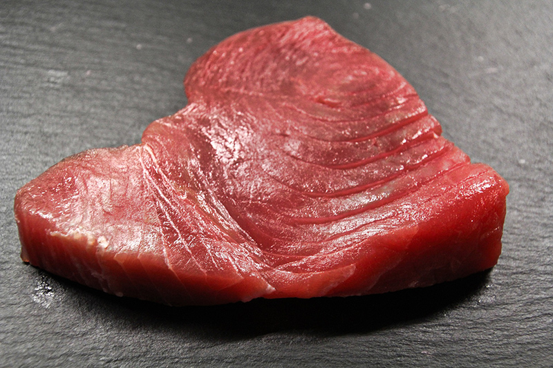 A cut of uncooked tuna steak
