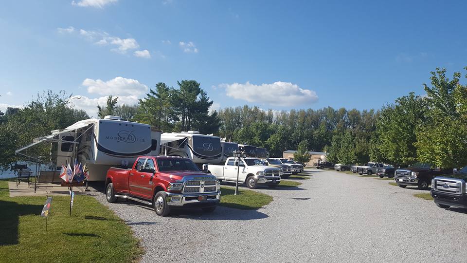 Pickup trucks parked in front of trailers along road