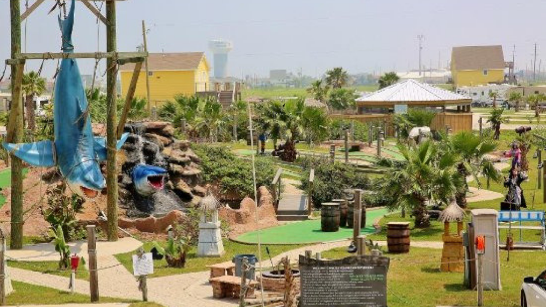 Sharks and palm trees add atmosphere to a miniature golf course in Jamaica RV Resort.
