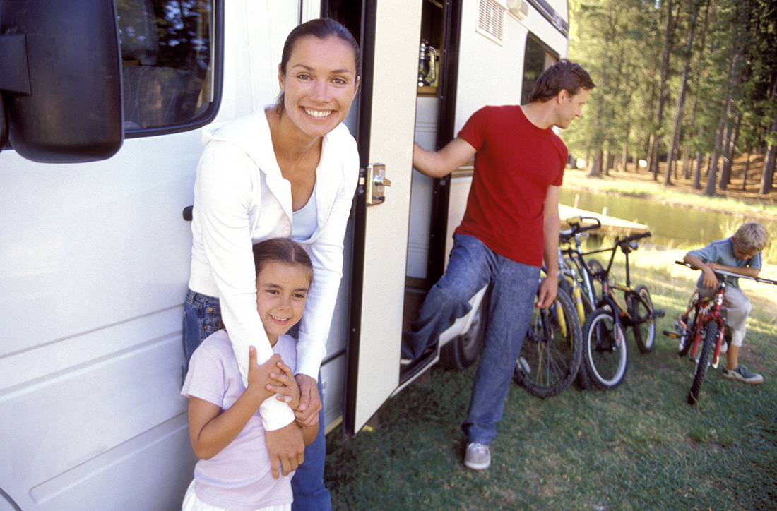 A family relaxing around their motorhome.