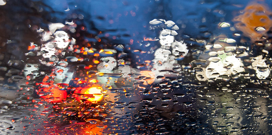 View through a rain-drop coated windshield.