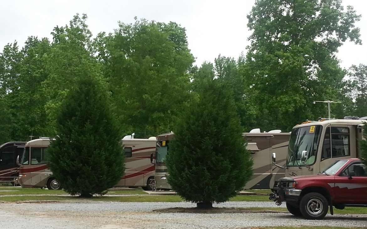 Red truck and RVs parked along gravel road