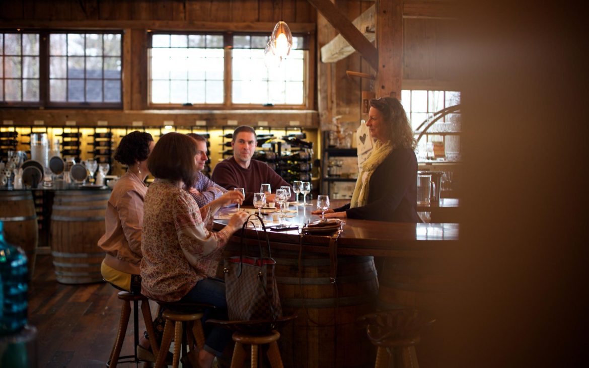 People wine tasting inside at bar