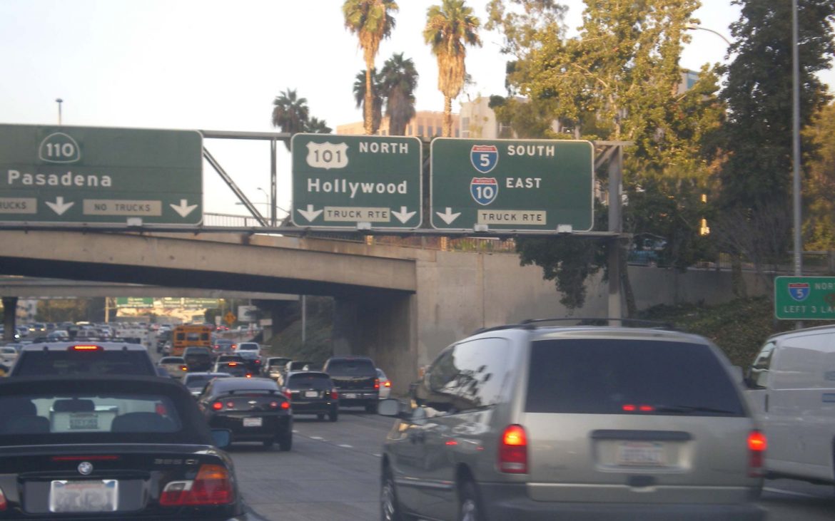 Slow traffic with brake lights shining at the junction of the Hollywood and Pasadena Freeways.