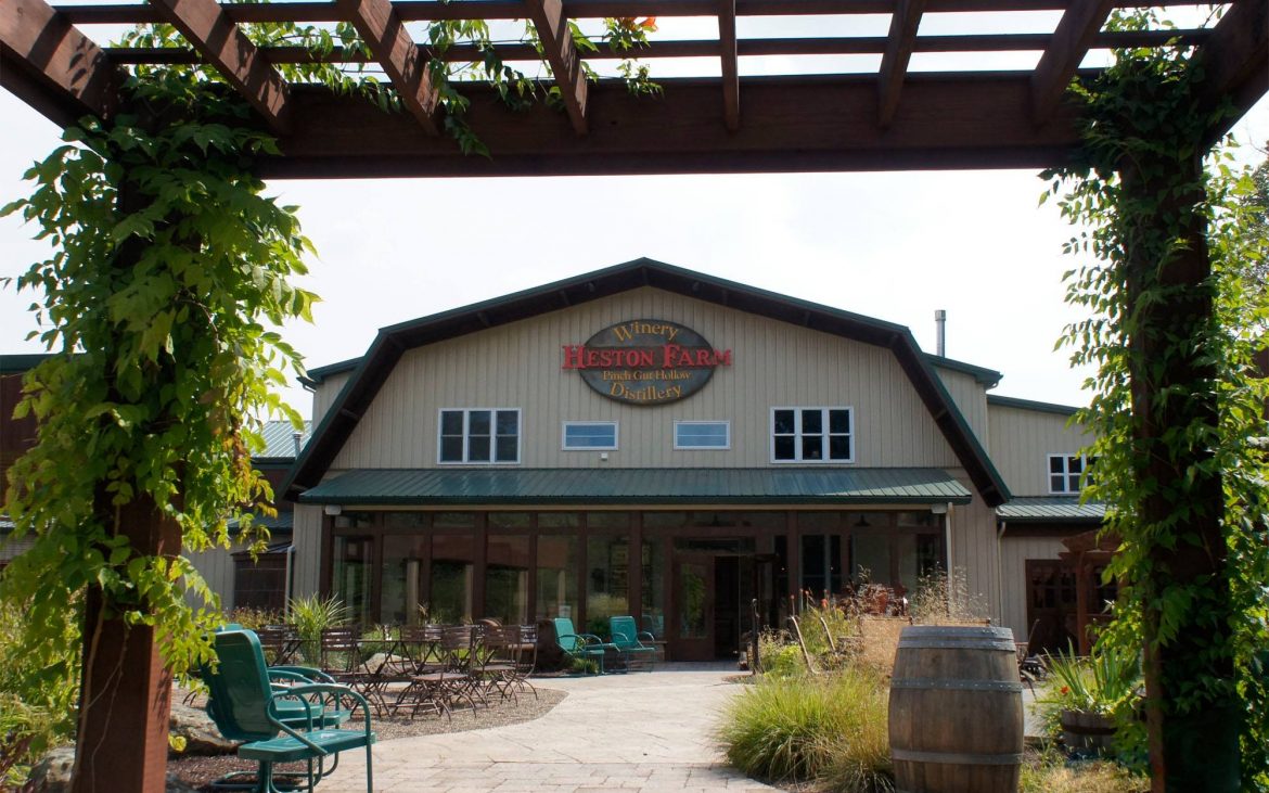 Farm building winery with outdoor lounge chairs and vines
