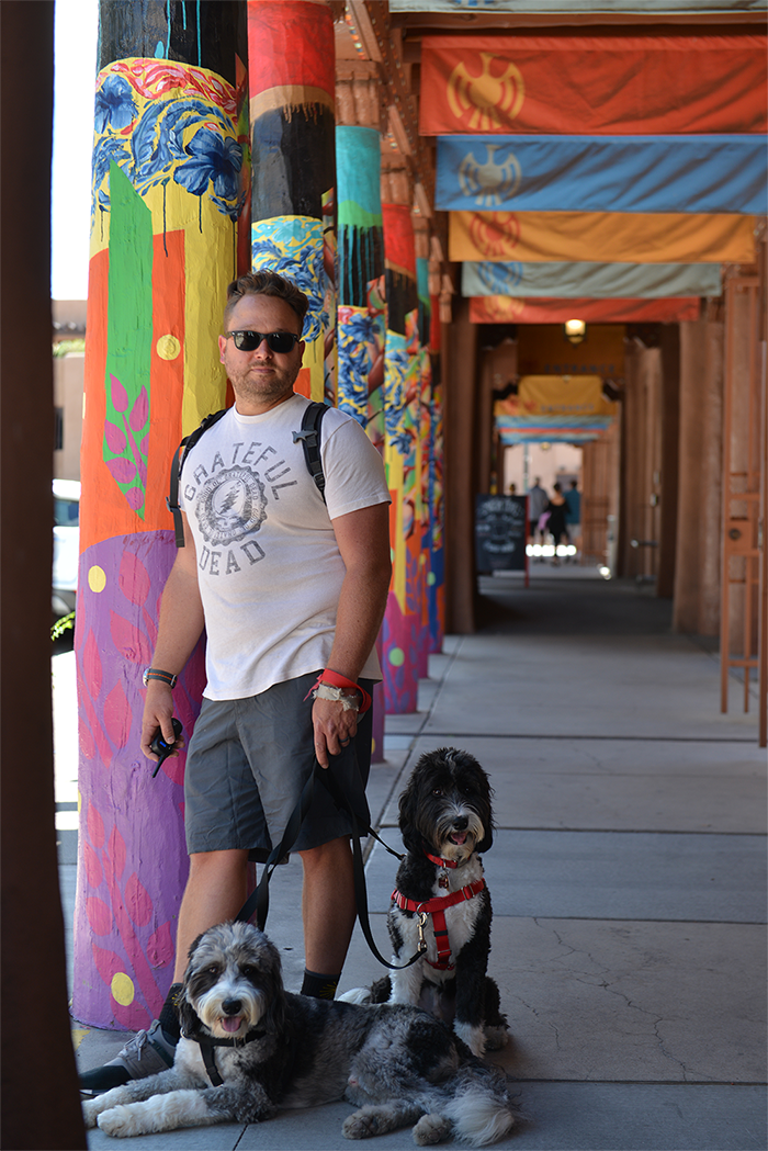 The author and his two dogs stand under an overhang at the Santa Fe Plaza.