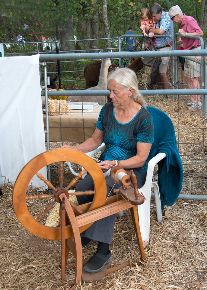 A Towns County resident demonstrates the age-old art of spinning thread on a wheel.