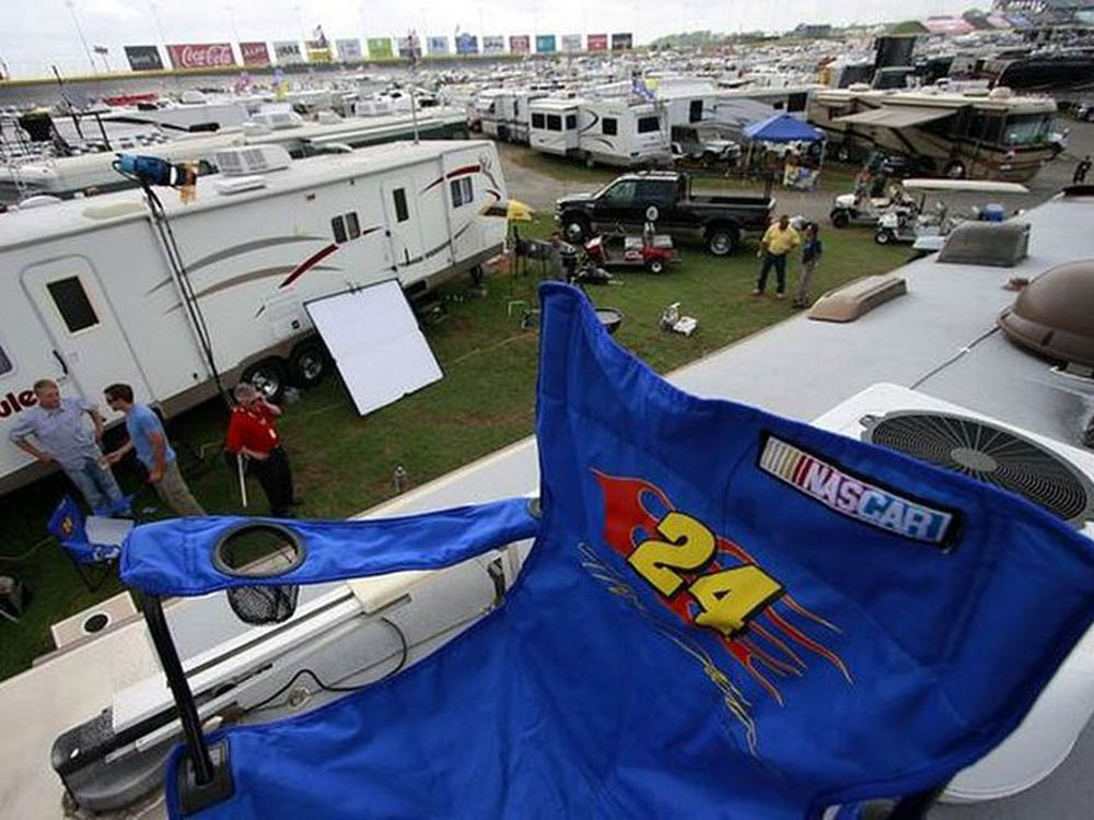 A blue folding chair on top of an RV at the Charlotte Raceway.