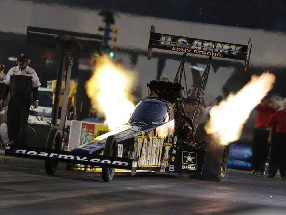 A drag racer shoots flames as it rockets off the starting line.