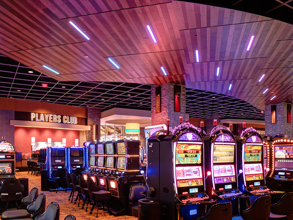 Colorful slot machines on the casino floor with a "players club" sign in the background.