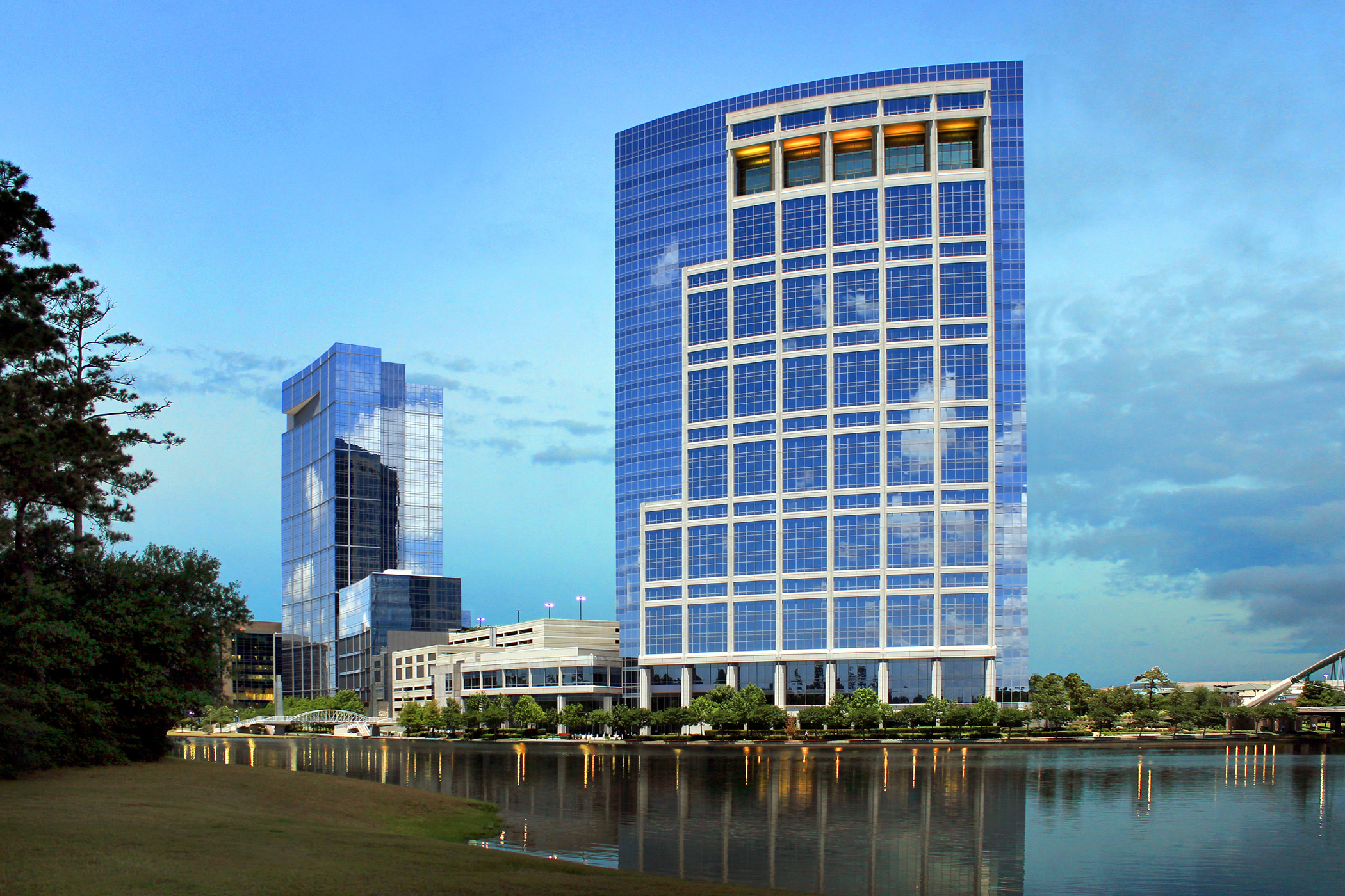 A gleaming office building reflected on the surface of a river