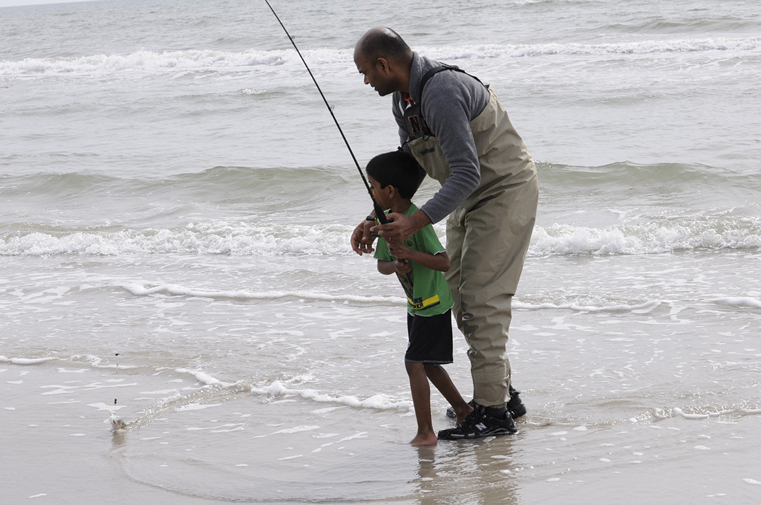 A father and son go ocean fishing. 
