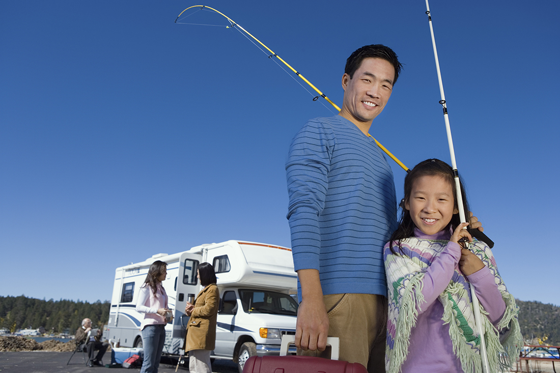 A father and daughter standing in front of an RV.