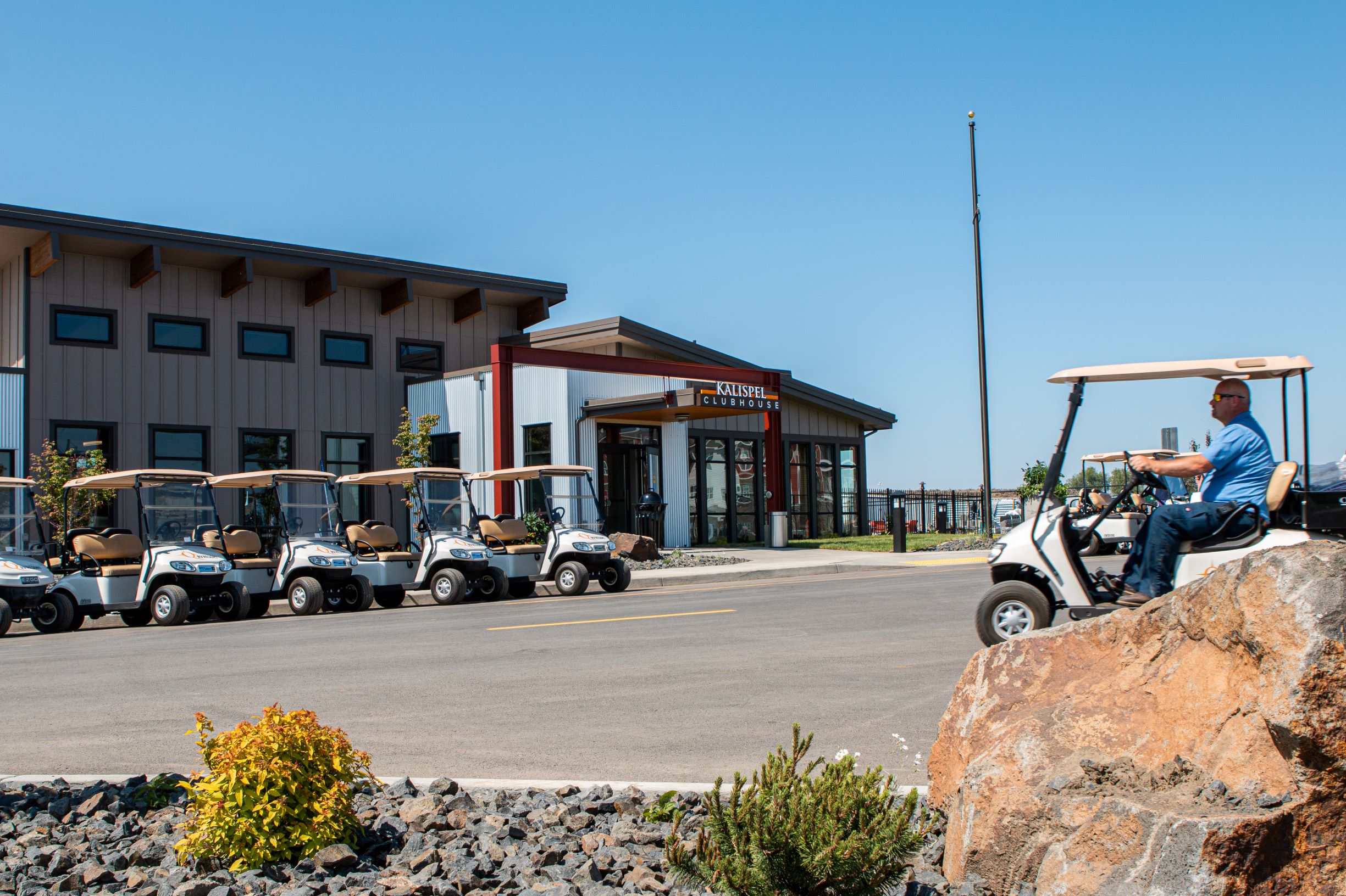 A line of golf cars parked in front of a Northern Quest building.