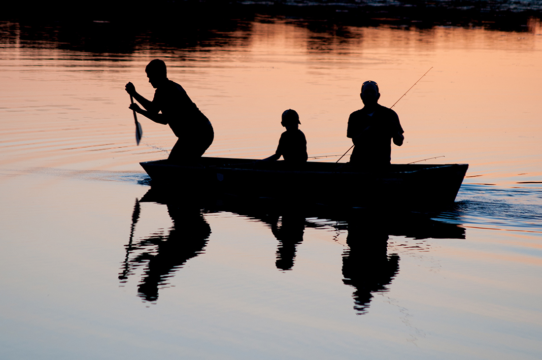 Silhouette of families on boat fishing.