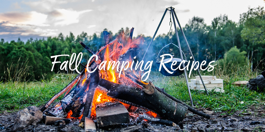 Flames roar in a tepee fire with camping tripod in the background, fall camping recipes.